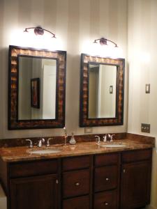 Designer Robin LaMonte's well-chosen bronze mirrors complement the neutral tones of this traditional bathroom.